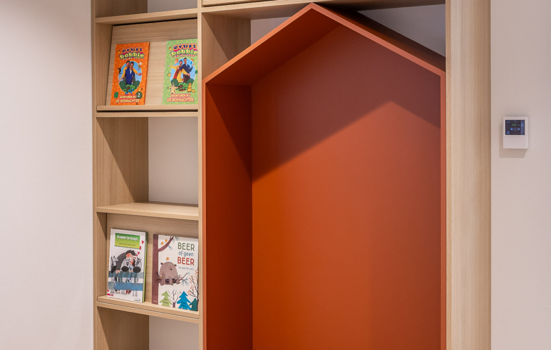 boekenkast met display en gekleurde zitnis in huisvorm