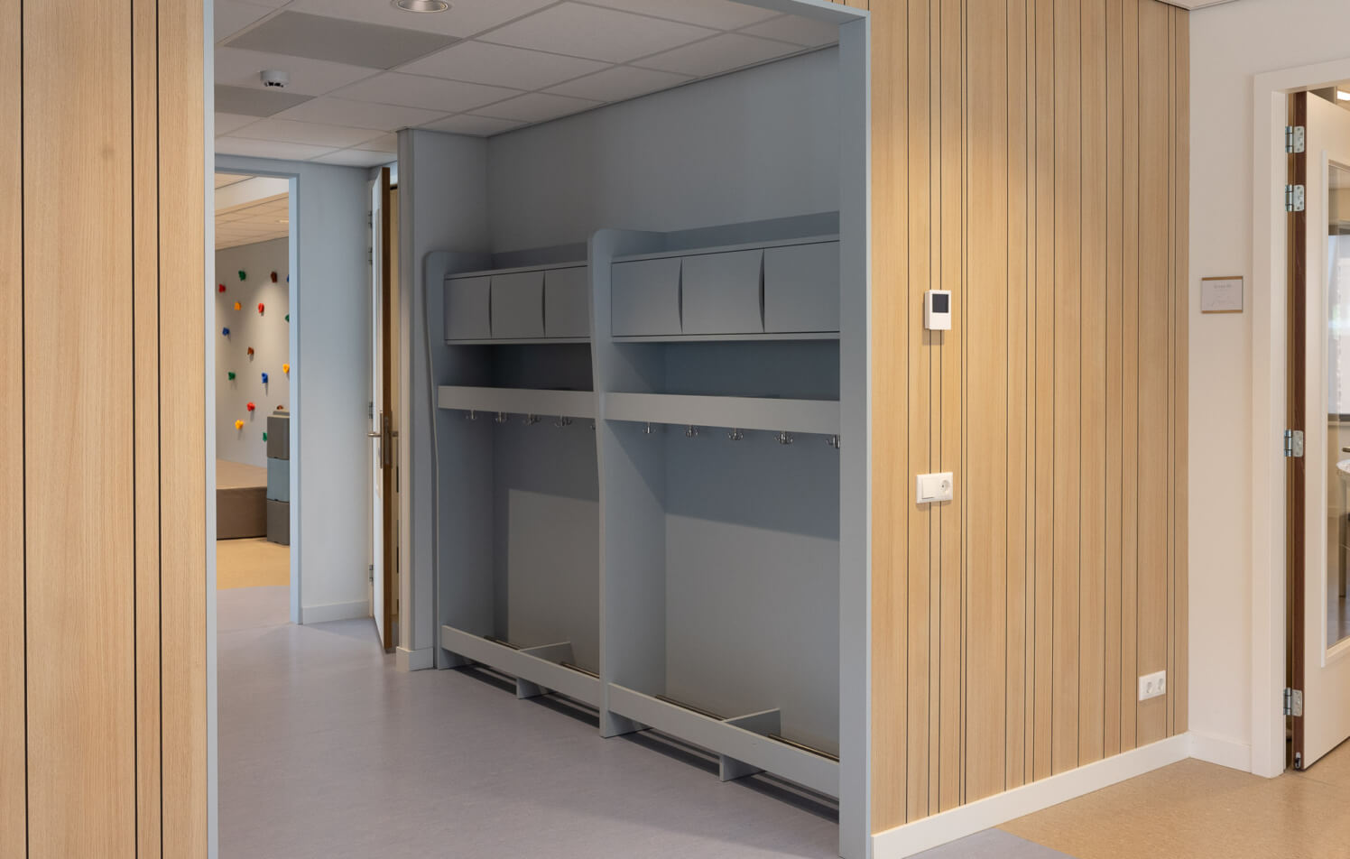 lichtblauwe garderobe op maat voor onderwijsinstelling met wandbekleding